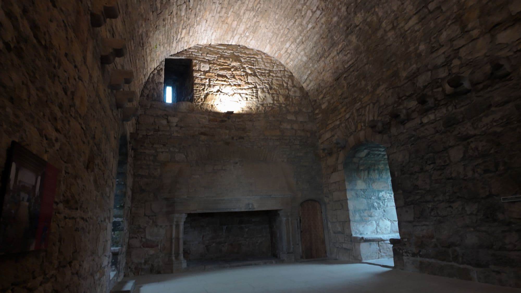 The great hall at Craigmillar, its vaulted stone ceiling lit from above and the huge fireplace on the far wall