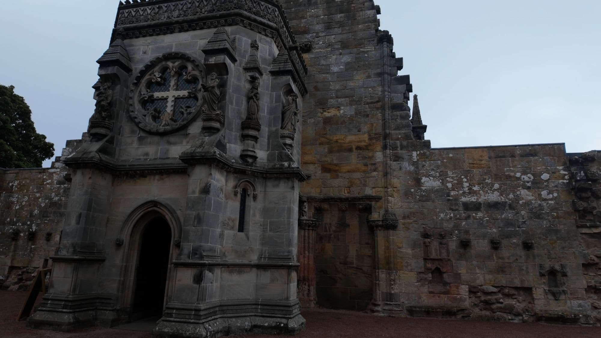 The west end of Rosslyn Chapel, where the unbuilt nave was meant to continue, with its carved rose window