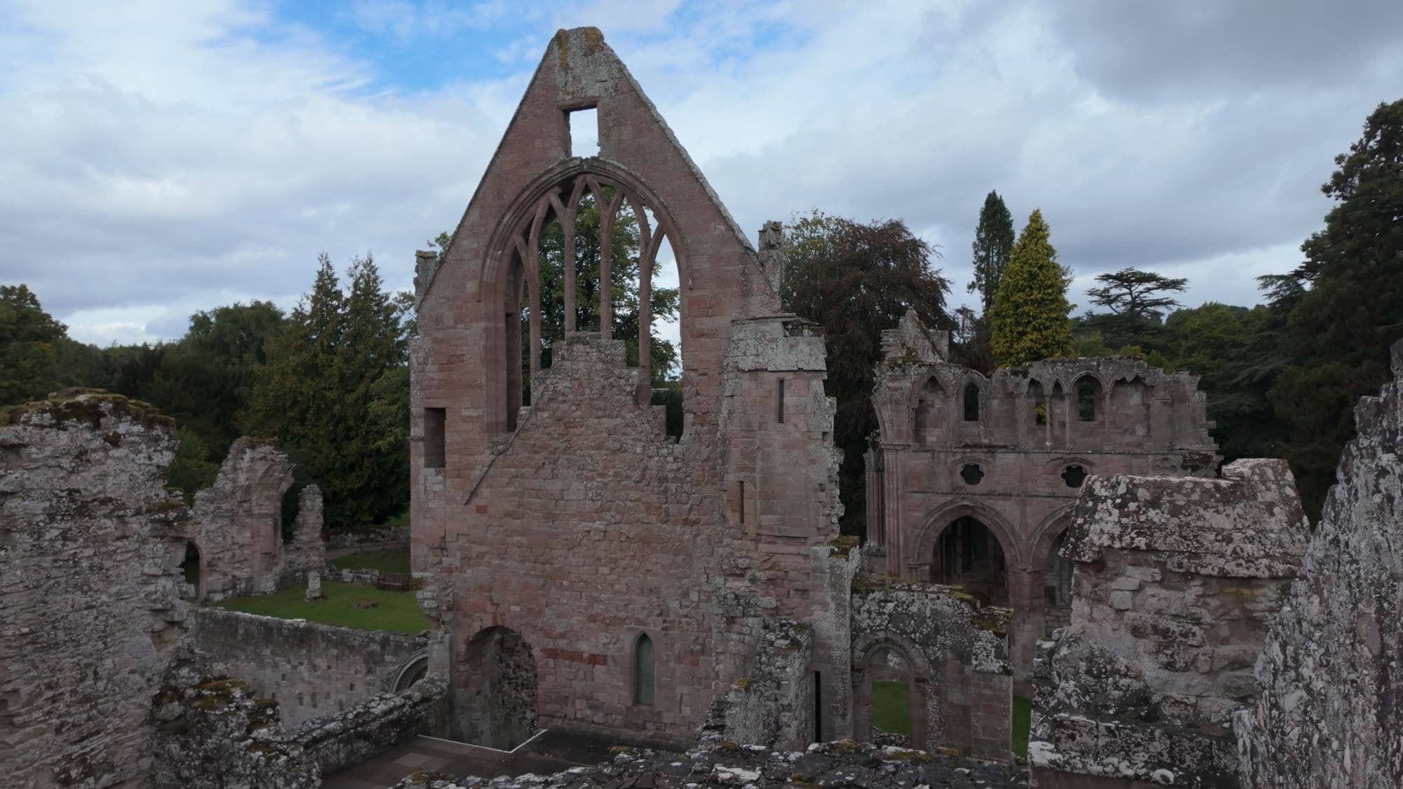 A tall gable with an empty pointed window rising over Dryburgh's ruined walls