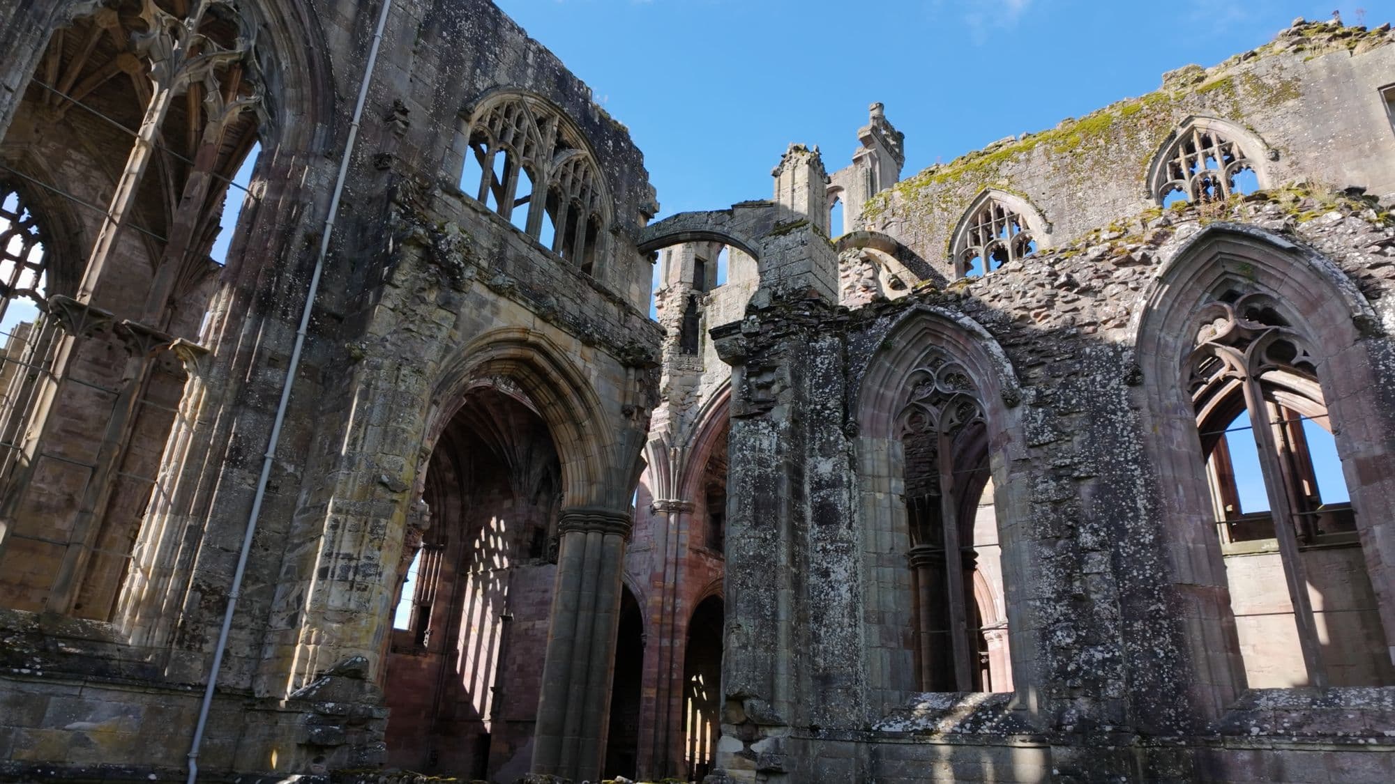 Inside the ruined nave, rows of pointed window openings and broken arches overhead