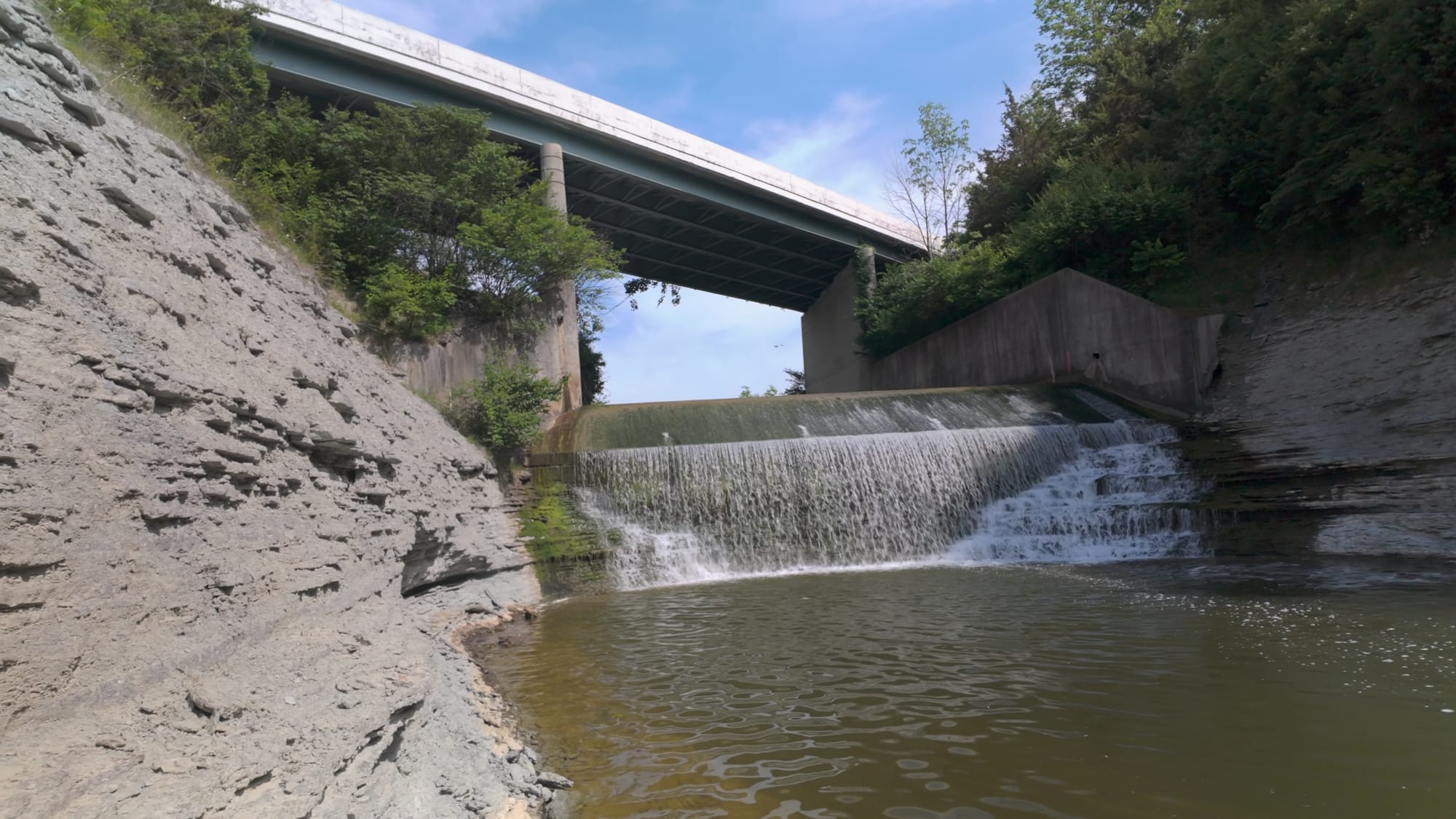 The Route 730 bridge above the dam outflow, water sheeting down the concrete apron into the creek below