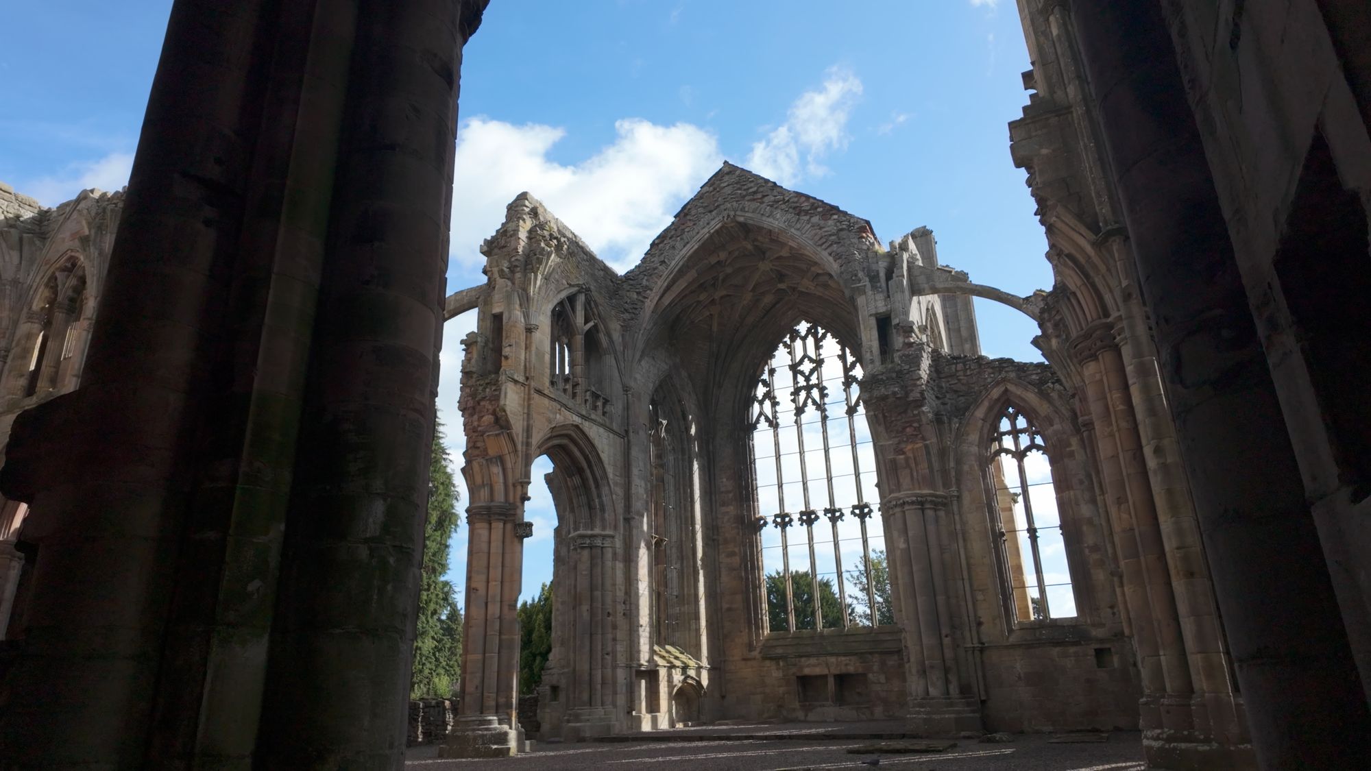 Looking down the ruined church toward the east end, the huge window framed between massive pillars