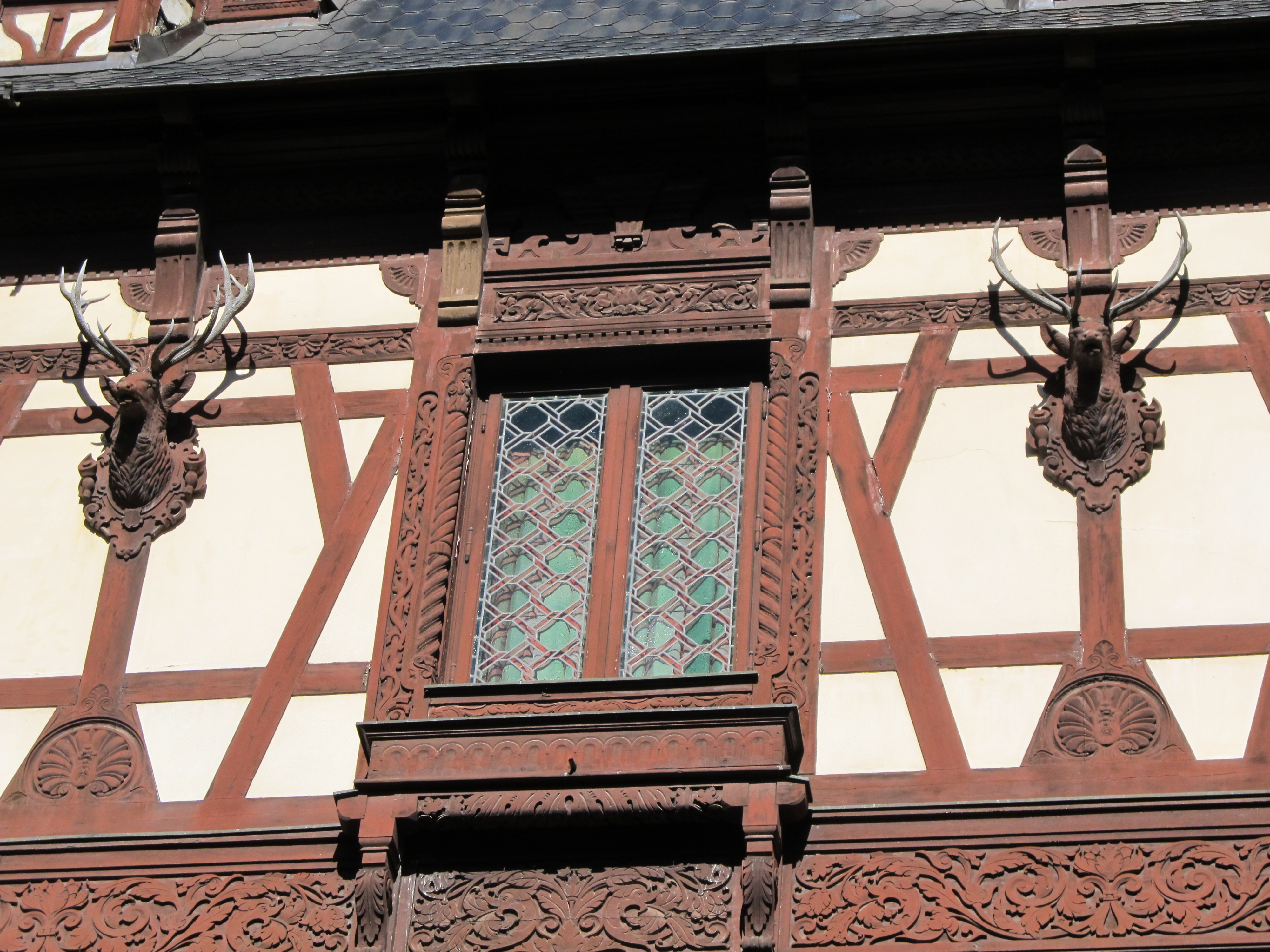 The ornate facade detail — deer heads, carved woodwork, and stained glass, and that's just the outside