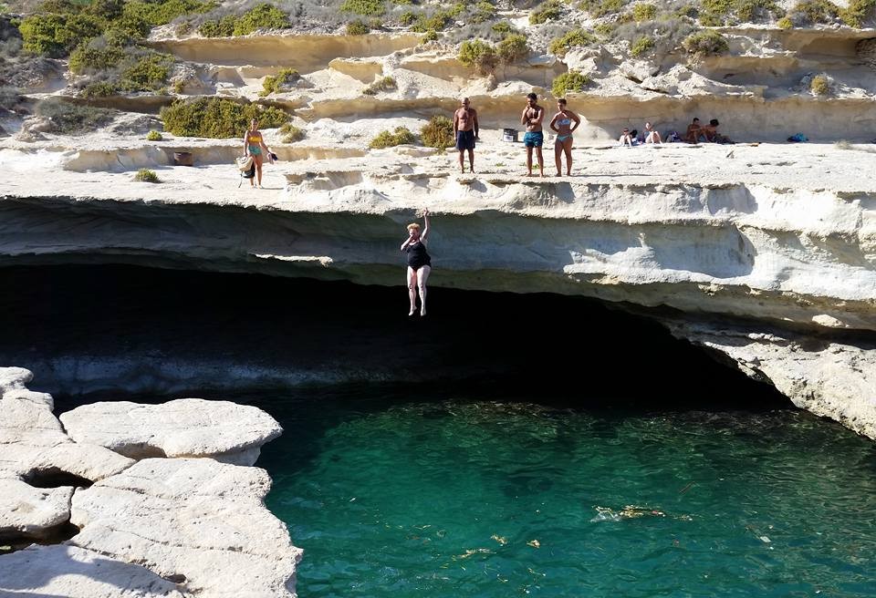 My mom launching herself off the cliff into the water at St. Peter's Pool, Malta
