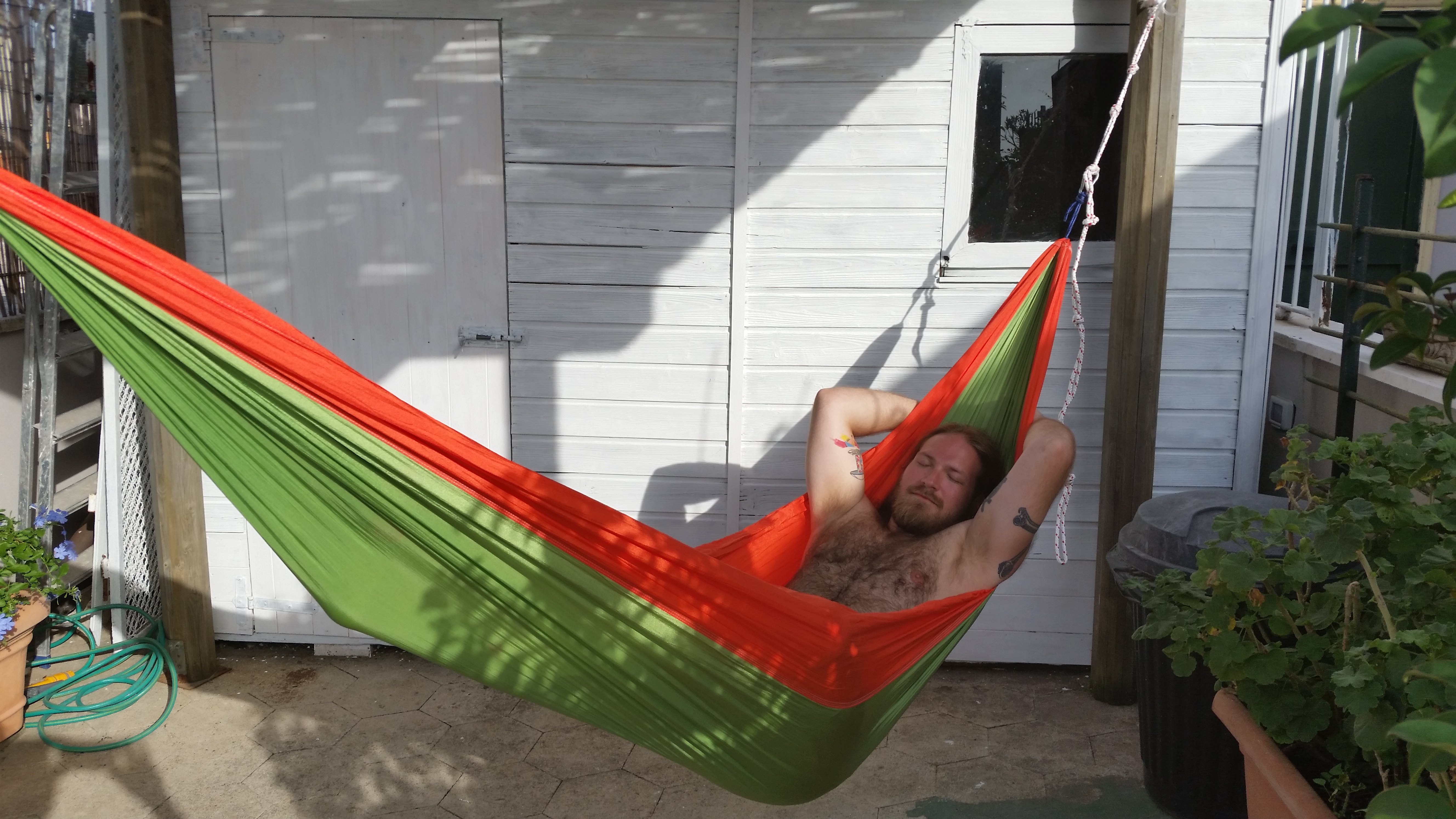 Me in a hammock on a rooftop terrace overlooking the Colosseum in Rome