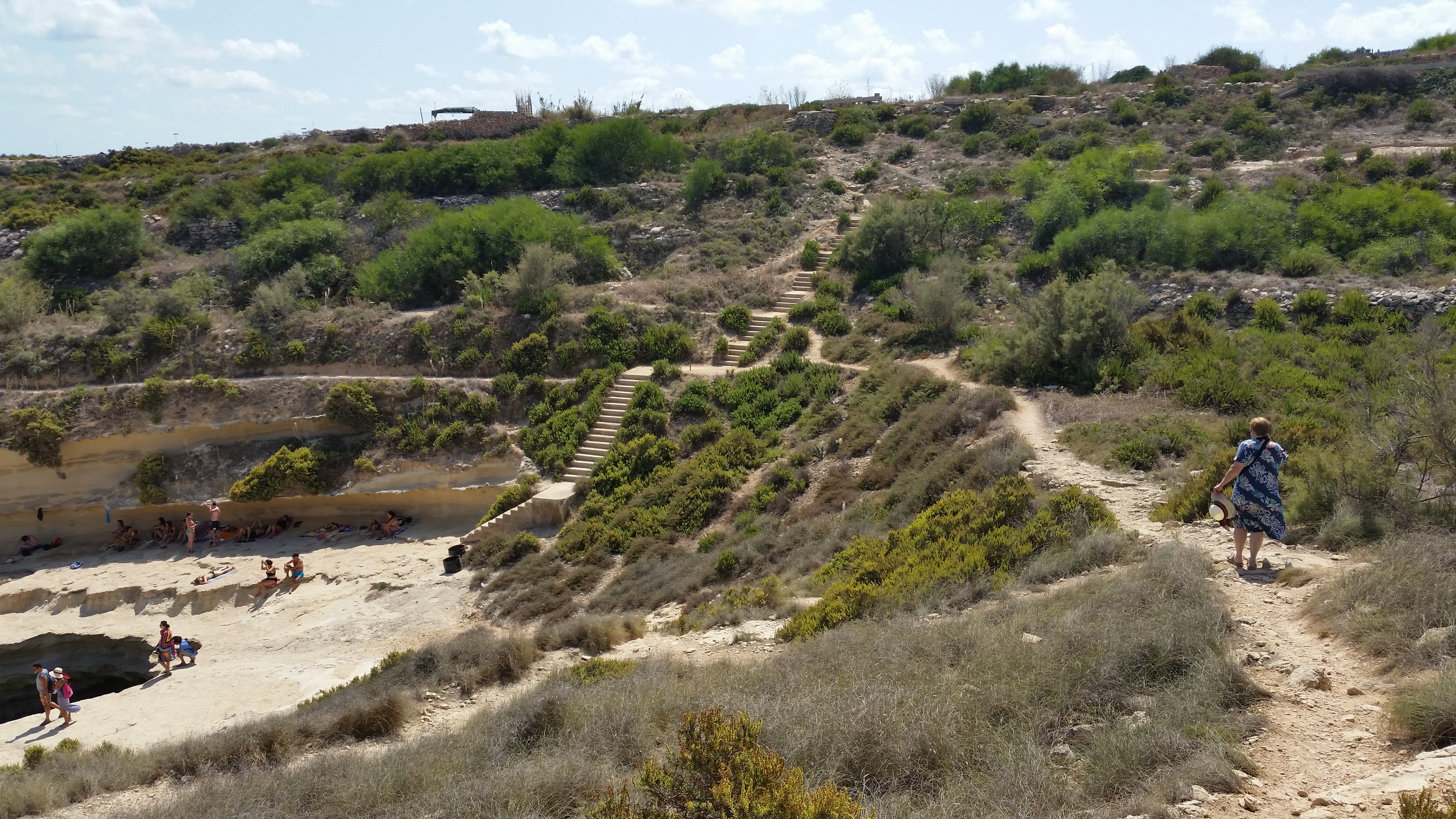 My mom walking toward the cliff edge at St. Peter's Pool, Malta