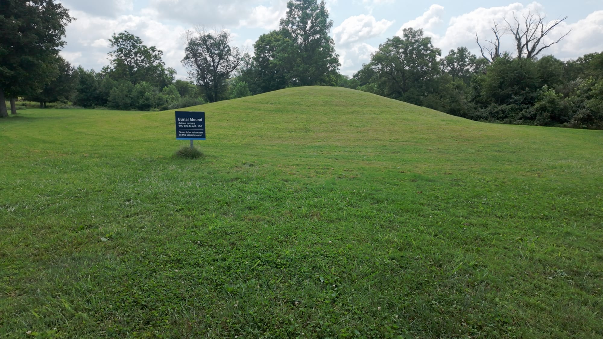 One of the Adena burial mounds on the Serpent Mound property, marked with a small sign and roped off from foot traffic