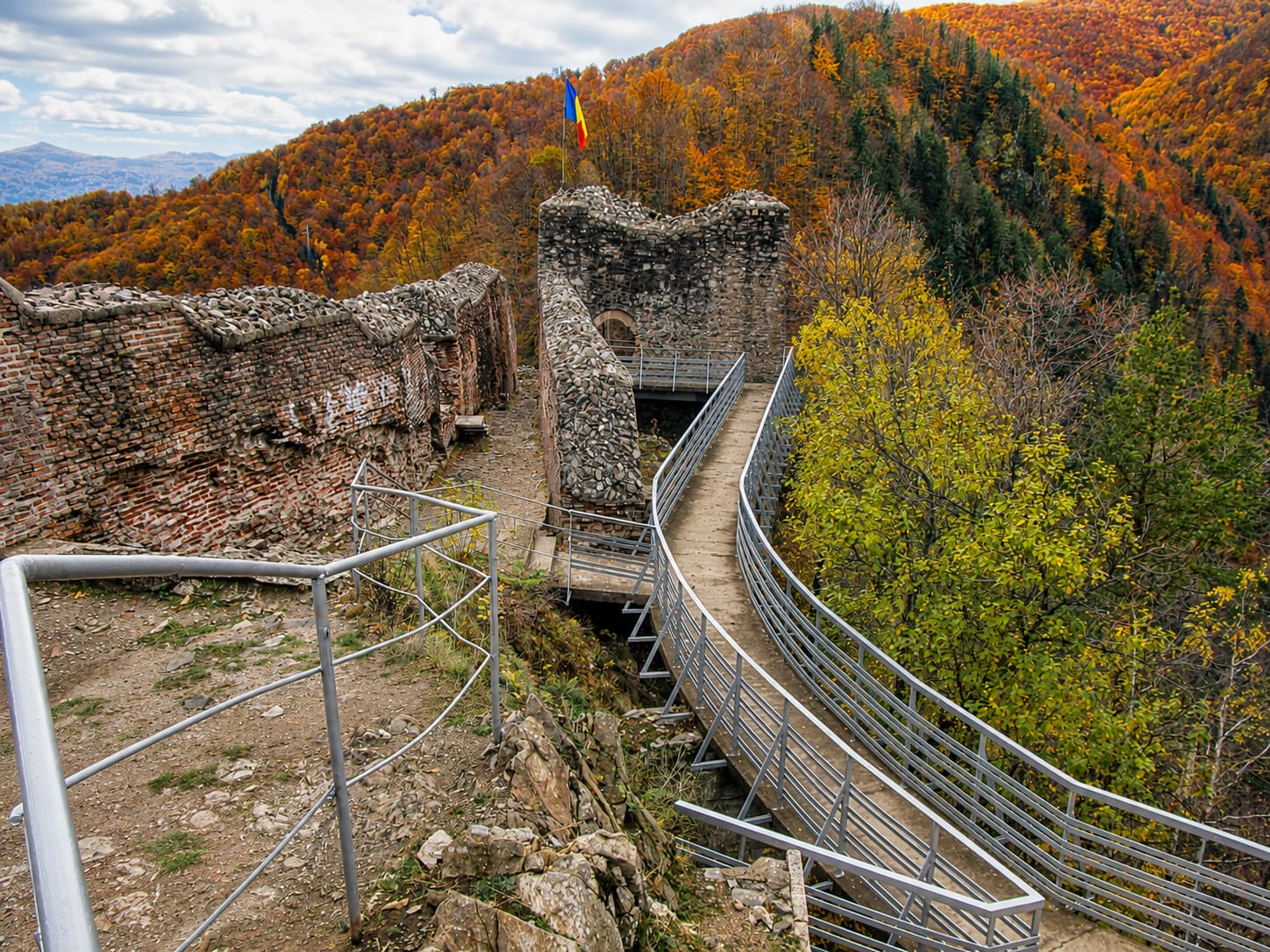 The ruins — crumbling walls, a cliff edge, and a view of the Argeș valley that goes on forever.