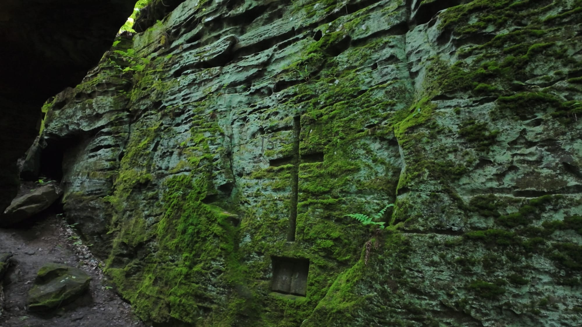 The carved cross and open Bible set into the ledge wall — a tribute to Nettie's churchgoing life